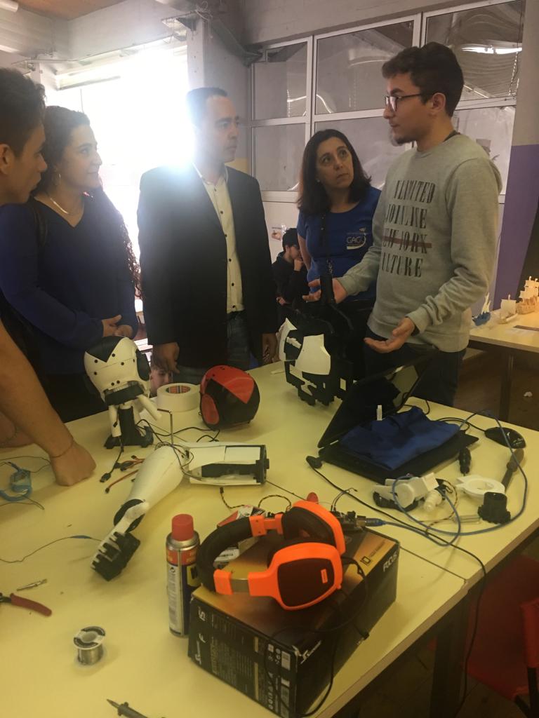 José Antunes explaining the robot's components to a group of visitors around a workbench at an open day.