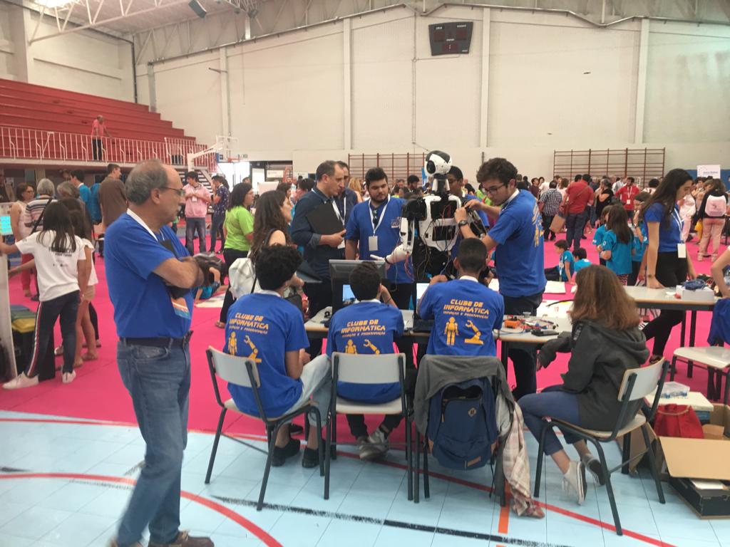 Wide view of the national robotics competition hall, with the club's stand and the robot visible among the teams.